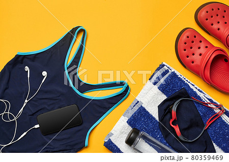Flat lay summer pool accessories on a yellow background. Colorful beach wear. 80359469