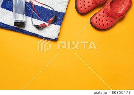 Flat lay summer pool accessories on a yellow background. Colorful beach wear. 80359478
