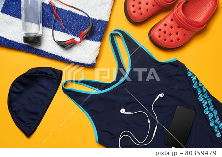 Flat lay summer pool accessories on a yellow background. Colorful beach wear. 80359479