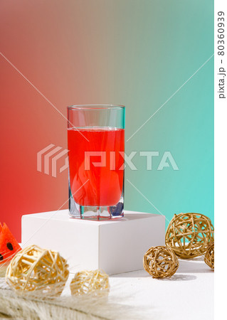 Fresh just squeezed watermelon drink on a red and blue background. Fresh just squeezed watermelon drink on a red and blue background. 80360939