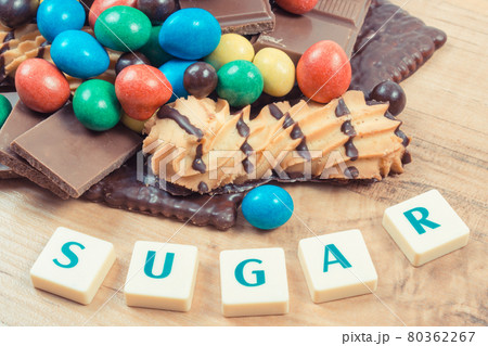 Inscription sugar and heap of sweets containing a lot of sugar. Unhealthy eating Inscription sugar and heap of sweets containing a lot of sugar. Unhealthy eating 80362267