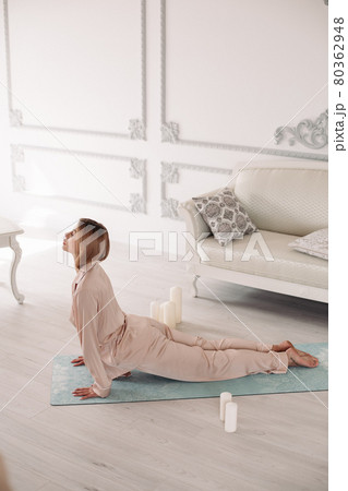 Young lady starting morning with yoga exercises in Young lady starting morning with yoga exercises in 80362948