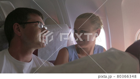 Young couple making selfie with cell in plane Young couple making selfie with cell in plane 80366348