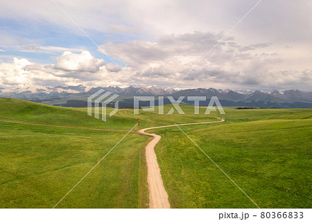 Mountain peaks and grassland are under white clouds. Mountain peaks and grassland are under white clouds. 80366833