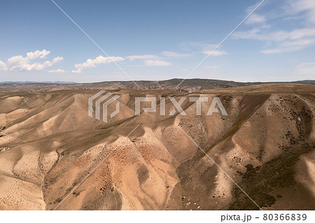 Mountain peaks and grassland are under white clouds. Mountain peaks and grassland are under white clouds. 80366839