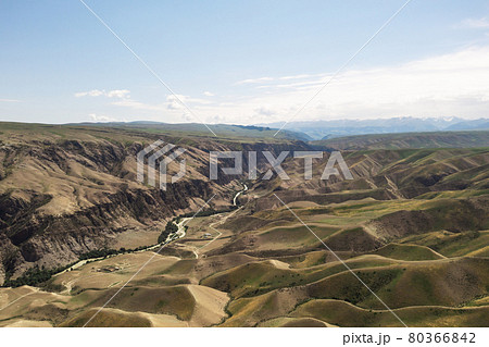 Mountain peaks and grassland are under white clouds. Mountain peaks and grassland are under white clouds. 80366842