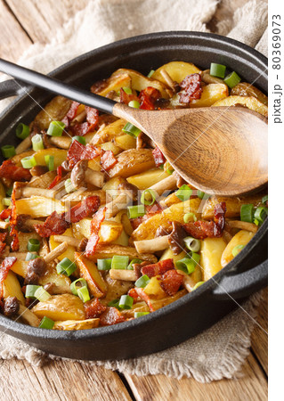 Fried potatoes with bacon and mushrooms close-up in a frying pan. Vertical 80369073