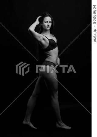 Slim tanned woman body over gray background 80369604