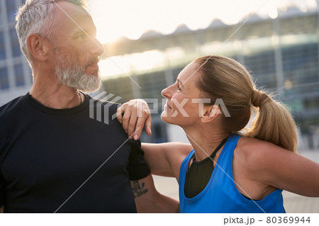 Portrait of loving mature couple, sporty man and woman having morning workout in the city on a summer day Portrait of loving mature couple, sporty man and woman having morning workout in the city on a summer day 80369944