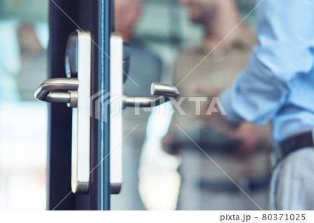 Businessman entering at work, opening glass door in the modern office, selective focus 80371025