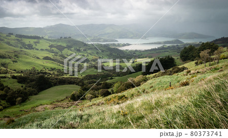 Storm approaching a valley with green rolling hills, storm approaching a valley with green rolling hills 80373741