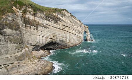 Big cliff leading into the ocean, shot at Cape Farewell, New Zealand 80375718