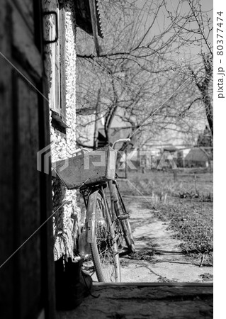 old bike stands near the wall, back view. Monochrome, black and white photo old bike stands near the wall, back view. Monochrome, black and white photo 80377474