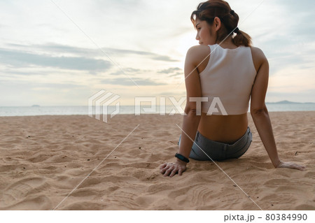 Woman sit on the beach in summer time. 80384990