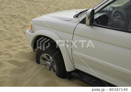 Hazards of desert drive - a car stuck in the sand 80387140