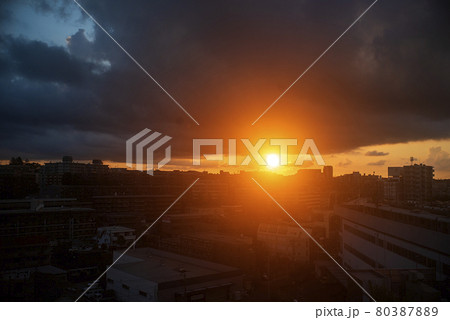 雲の下に顔をのぞかせた日の出の輝き 80387889