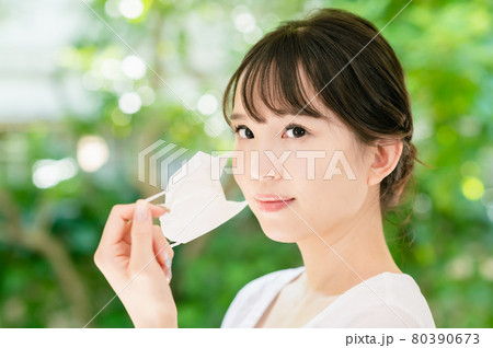 マスクをつけて出かける若い女性 80390673