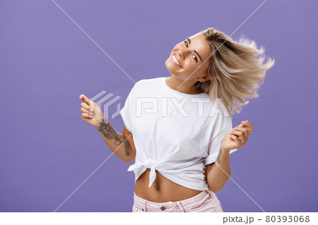 Portrait of happy carefree attractive woman dancing and waving hair from rejoice and cheer smiling broadly tilting head celebrating end or working day enjoying nice sunny day on beach over purple wall Portrait of happy carefree attractive woman dancing and waving hair from rejoice and cheer smiling broadly tilting head celebrating end or working day enjoying nice sunny day on beach over purple wall 80393068