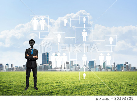 Camera headed man standing on green grass against modern cityscape Camera headed man standing on green grass against modern cityscape 80393809