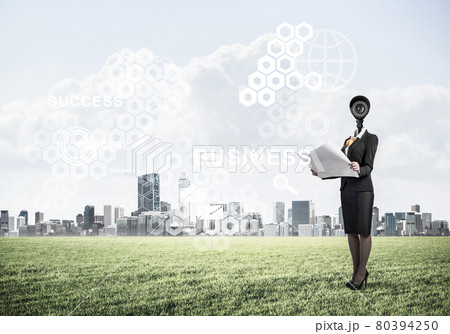 Camera headed woman standing on green grass against modern citys Camera headed woman standing on green grass against modern citys 80394250