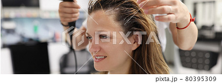 Woman in a beauty salon dry her head with hairdryer Woman in a beauty salon dry her head with hairdryer 80395309