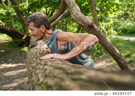 Senior fitness man training push up outside in the forest in summer 80395537