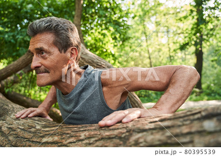 Senior fitness man training push up outside in the forest in summer 80395539
