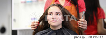 Master hairdresser holds hair of client in beauty salon Master hairdresser holds hair of client in beauty salon 80396014