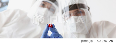 Two doctors in protective suits and goggles are holding shelf and test tube for taking biological materia 80396120