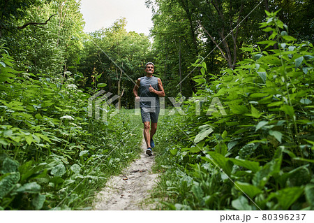 Man jogging in summer park in morning while training and listening sounds of nature Man jogging in summer park in morning while training and listening sounds of nature 80396237