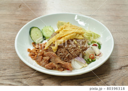 rice mixed with shrimp paste topping slice Thai egg omelette couple sweet pork in gravy and vegetable on plate 80396318