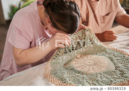 Woman with special needs peeping under the patterned napkin and checking 80396329