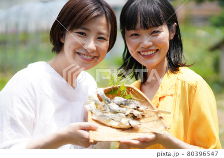 鮎の塩焼きを持つ女性 鮎の塩焼きを持つ女性 80396547