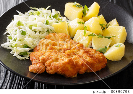 Polish Breaded Pork Cutlets Kotlet Schabowy with boiled potatoes and cabbage salad close-up in a plate. Horizontal Polish Breaded Pork Cutlets Kotlet Schabowy with boiled potatoes and cabbage salad close-up in a plate. Horizontal 80396798