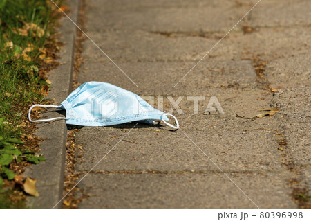 Disposable face mask dropped on the street Disposable face mask dropped on the street 80396998