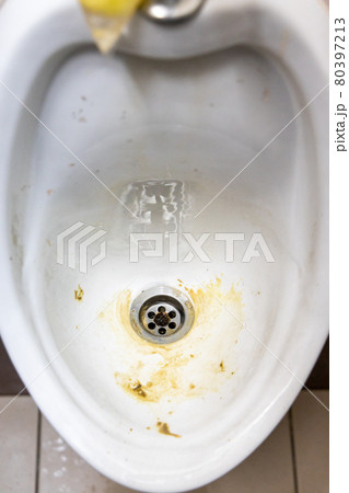 Close-up of dirty and smelly urinal bowl with limescale stain deposits 80397213