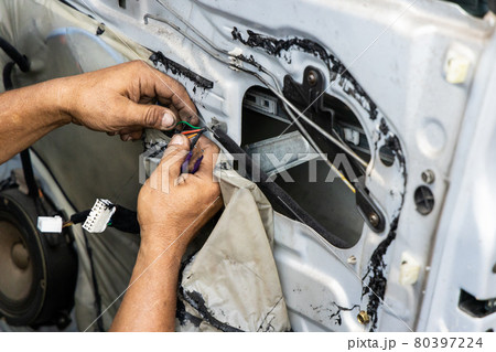 Auto technician diagnose and fixing wiring problem of car door 80397224