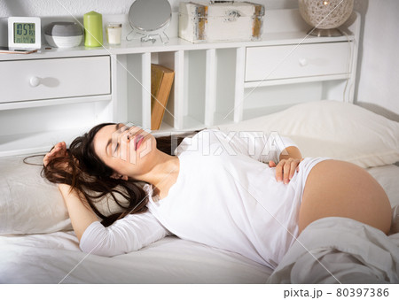 Young woman in white sleepwear is sleeping on bed 80397386