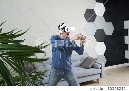 Man with virtual reality headset is playing game. 80398252