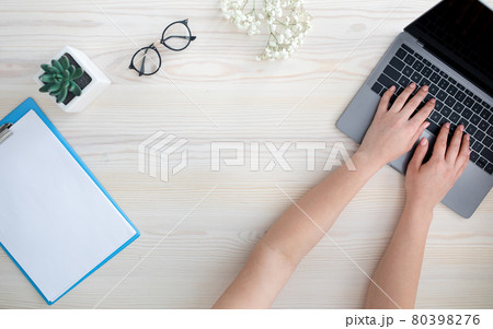 Top view of female hands typing on laptop keyboard, sitting at table, free space Top view of female hands typing on laptop keyboard, sitting at table, free space 80398276