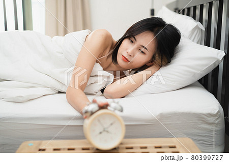 Young woman sleeping and alarm clock in the bedroom at home Young woman sleeping and alarm clock in the bedroom at home 80399727