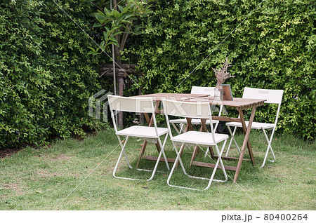 Wooden table with chairs and flower pot in garden on backyard Wooden table with chairs and flower pot in garden on backyard 80400264