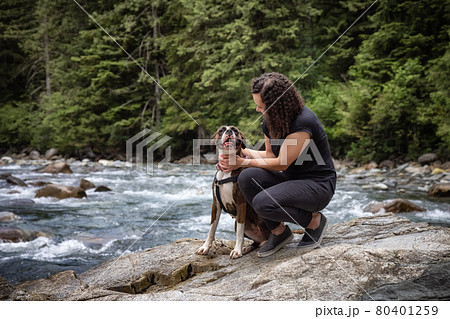 Woman hiking with Boxer Dog in the Canadian Nature Woman hiking with Boxer Dog in the Canadian Nature 80401259