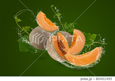 Water splashing on whole and slice of orange japanese melons or cantaloupe melon with seeds isolated on green background Water splashing on whole and slice of orange japanese melons or cantaloupe melon with seeds isolated on green background 80401495