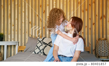 Funny preschooler girl with curly hair approaches mother Funny preschooler girl with curly hair approaches mother 80401857