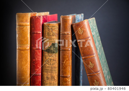 Row of old books on dark background Row of old books on dark background 80401946