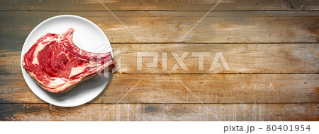 Beef prime rib and plate isolated on old wooden background. Horizontal banner Beef prime rib and plate isolated on old wooden background. Horizontal banner 80401954