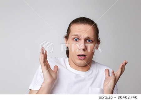 scared man in t-shirt isolated on gray background. 80403740