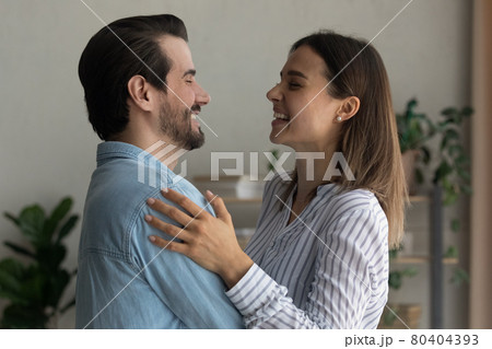Cheery spouses standing indoor hugging laughing enjoy happy harmonic relations Cheery spouses standing indoor hugging laughing enjoy happy harmonic relations 80404393
