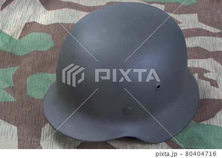 German Nazi Army steel helmet World War II period (1933-1945) on camouflaged background 80404716